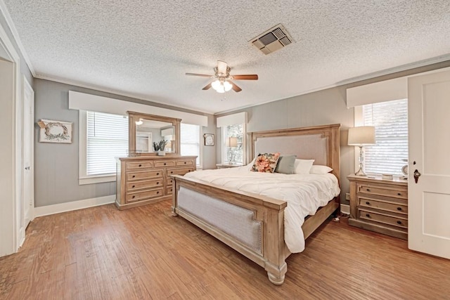 3508 Moulton Rd, Gonzales, TX 78629 - bedroom with light wood-type flooring, crown molding, multiple windows, a textured ceiling, and ceiling fan