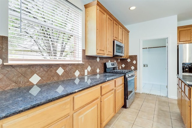 12608 Chittim Cir, Austin, TX 78732 - kitchen with stainless steel appliances, light tile patterned flooring, decorative backsplash, and dark stone countertops