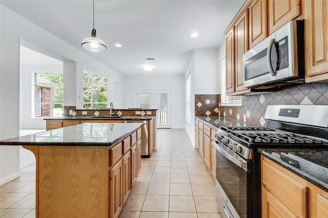 12608 Chittim Cir, Austin, TX 78732 - kitchen with appliances with stainless steel finishes, a center island, tasteful backsplash, plenty of natural light, and recessed lighting