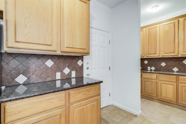 12608 Chittim Cir, Austin, TX 78732 - kitchen with dark stone counters, decorative backsplash, light tile patterned floors, and light brown cabinetry