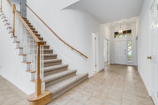 12608 Chittim Cir, Austin, TX 78732 - foyer entrance with light tile patterned flooring, stairway, and a towering ceiling
