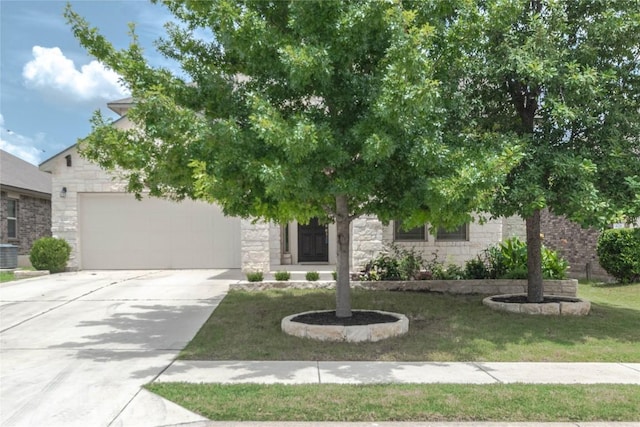 632 Schefer St, Leander, TX 78641 - obstructed view of property featuring an attached garage, stone siding, driveway, and a front lawn