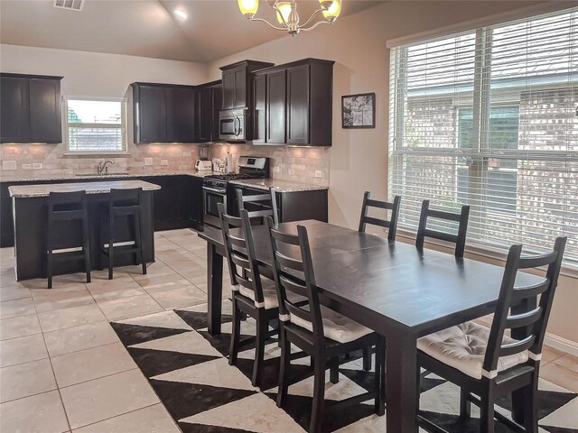632 Schefer St, Leander, TX 78641 - dining room featuring light tile patterned floors, vaulted ceiling, and a chandelier