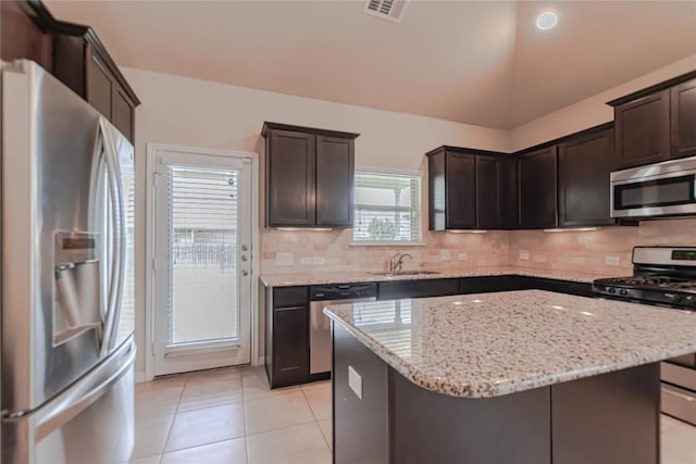 632 Schefer St, Leander, TX 78641 - kitchen with stainless steel appliances, dark brown cabinets, and light tile patterned floors