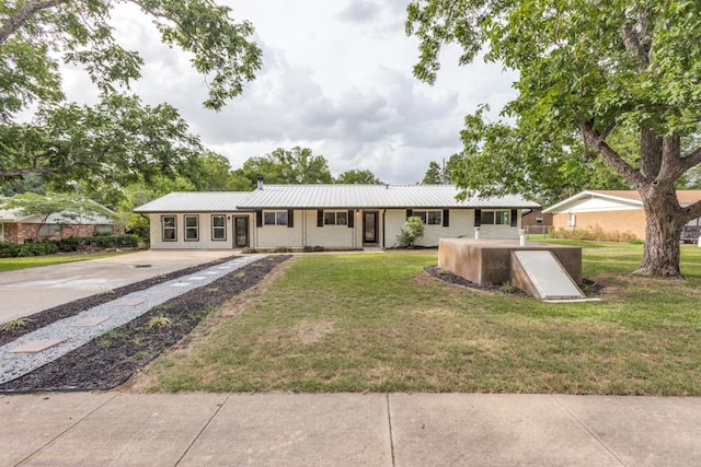 606 Lilac Dr, Round Rock, TX 78664 - single story home with driveway, a front lawn, and a metal roof