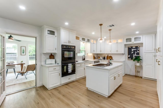 606 Lilac Dr, Round Rock, TX 78664 - kitchen with light countertops, black appliances, a center island, light wood-type flooring, and recessed lighting