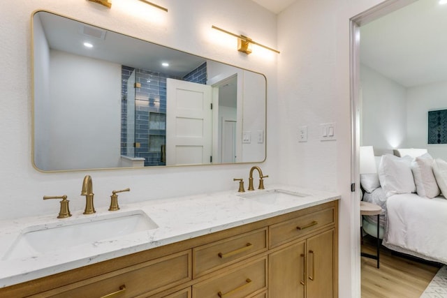 606 Lilac Dr, Round Rock, TX 78664 - full bath with double vanity, connected bathroom, wood finished floors, tiled shower, and recessed lighting