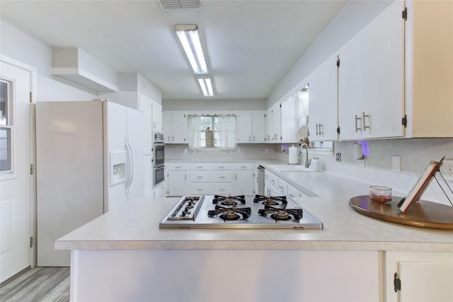 400 N Brazos St, Granger, TX 76530 - kitchen with appliances with stainless steel finishes, light countertops, a peninsula, and white cabinetry