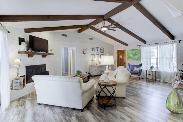 400 N Brazos St, Granger, TX 76530 - living area featuring a brick fireplace, a ceiling fan, and wood finished floors