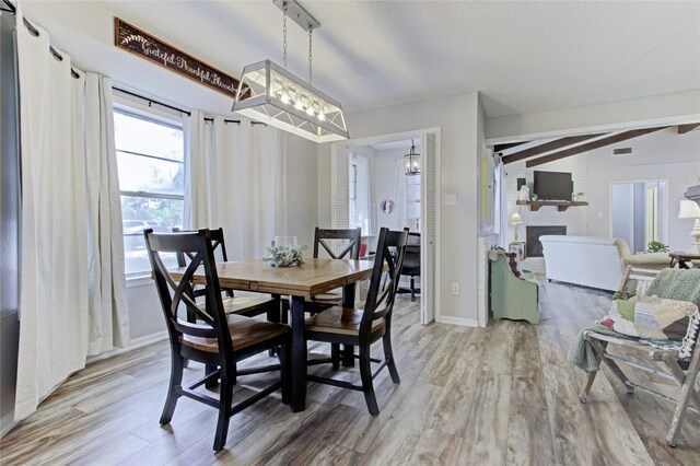 400 N Brazos St, Granger, TX 76530 - dining space featuring wood finished floors, a large fireplace, and a chandelier