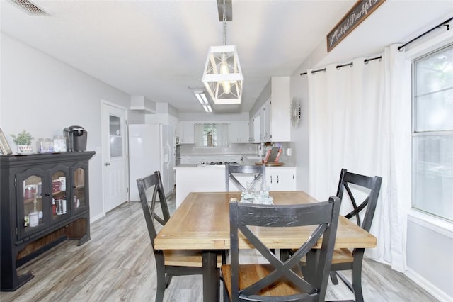 400 N Brazos St, Granger, TX 76530 - dining space with light wood finished floors and a chandelier