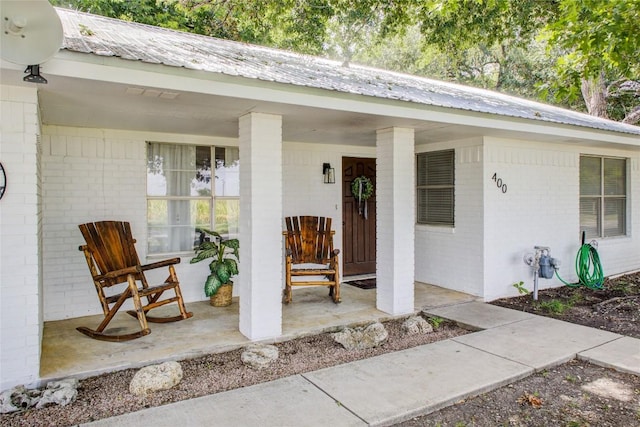 400 N Brazos St, Granger, TX 76530 - view of exterior entry with brick siding, covered porch, and a metal roof