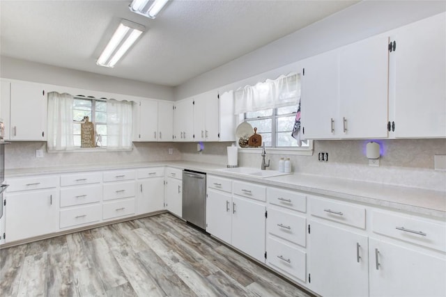 400 N Brazos St, Granger, TX 76530 - kitchen featuring dishwasher, light countertops, decorative backsplash, and white cabinetry