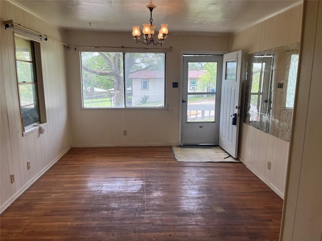 4307 Leslie Ave, Austin, TX 78721 - entryway featuring wood-type flooring, a chandelier, plenty of natural light, wood walls, and ornamental molding