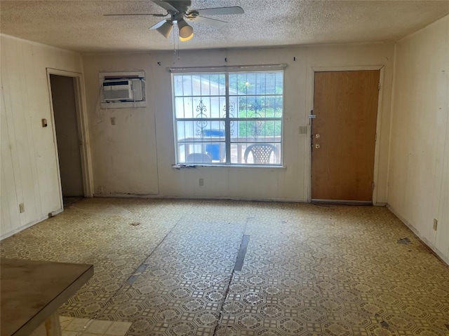 4307 Leslie Ave, Austin, TX 78721 - unfurnished living room with a ceiling fan, a textured ceiling, and an AC wall unit