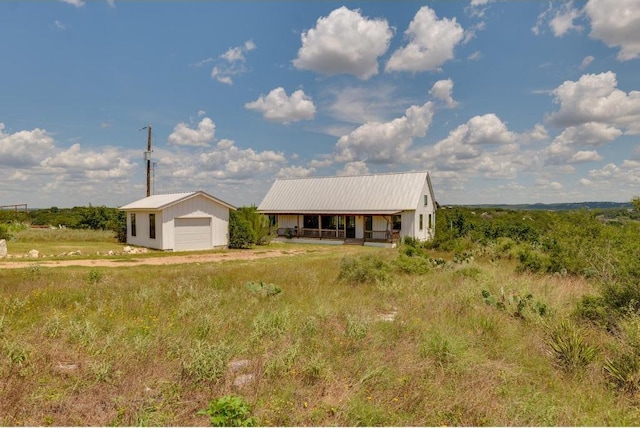 25633 Pedernales Point Dr, Spicewood, TX 78669 - view of front of home with an outbuilding, a detached garage, a porch, and a metal roof