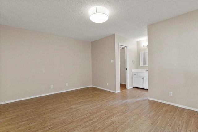 901 Pack Saddle Pass, Round Rock, TX 78681 - unfurnished room with light wood-type flooring and a textured ceiling
