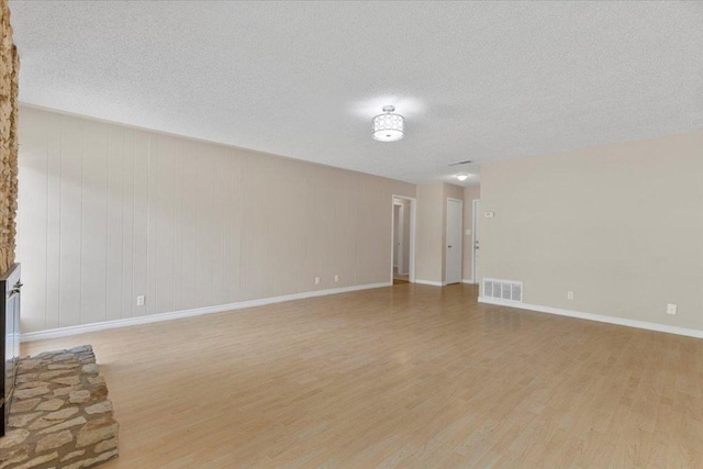901 Pack Saddle Pass, Round Rock, TX 78681 - unfurnished living room featuring light wood-style flooring and a textured ceiling