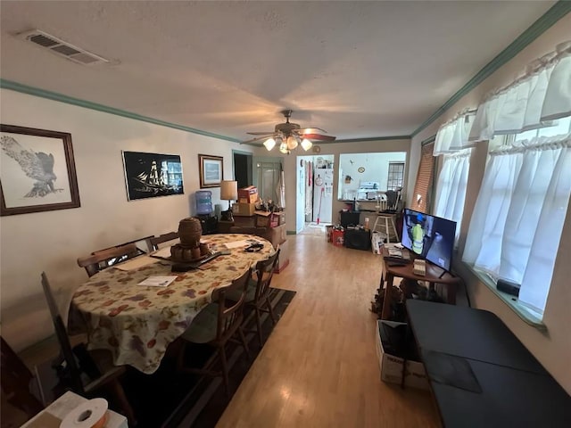 321 Douglas St, Lexington, TX 78947 - dining area with light wood-style flooring, crown molding, and a ceiling fan
