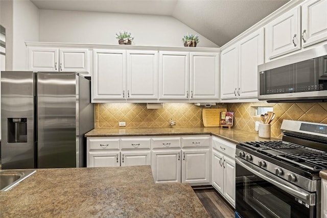 3792 Turetella Dr, Round Rock, TX 78681 - kitchen featuring appliances with stainless steel finishes, vaulted ceiling, white cabinets, tasteful backsplash, and dark wood-style flooring