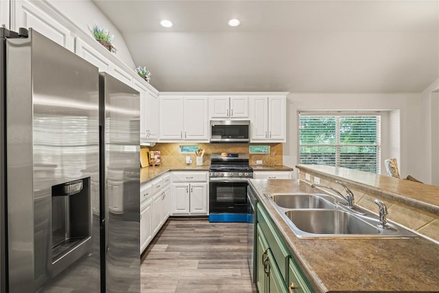 3792 Turetella Dr, Round Rock, TX 78681 - kitchen featuring appliances with stainless steel finishes, white cabinets, wood finished floors, backsplash, and recessed lighting