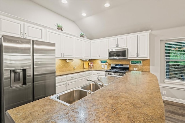 3792 Turetella Dr, Round Rock, TX 78681 - kitchen featuring stainless steel appliances, vaulted ceiling, white cabinetry, wood finished floors, and recessed lighting