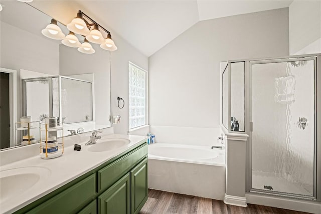 3792 Turetella Dr, Round Rock, TX 78681 - bathroom with a shower stall, a garden tub, wood finished floors, double vanity, and vaulted ceiling