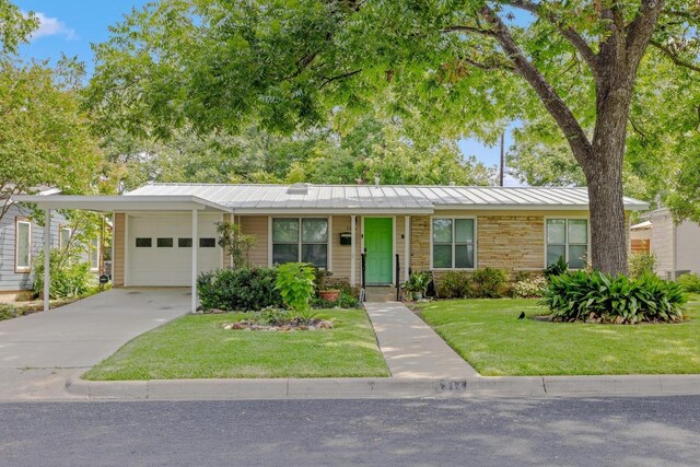 1314 Cloverleaf Dr, Austin, TX 78723 - view of front of house with a standing seam roof, an attached garage, a front lawn, concrete driveway, and a metal roof