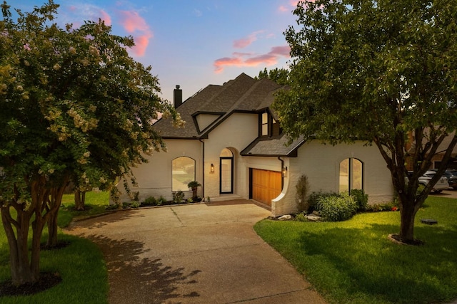 12309 Carlsbad Dr, Austin, TX 78738 - french country inspired facade featuring a chimney, an attached garage, driveway, a lawn, and a shingled roof