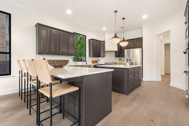 12309 Carlsbad Dr, Austin, TX 78738 - kitchen featuring a center island, light wood-type flooring, a kitchen breakfast bar, stainless steel refrigerator with ice dispenser, and light stone counters