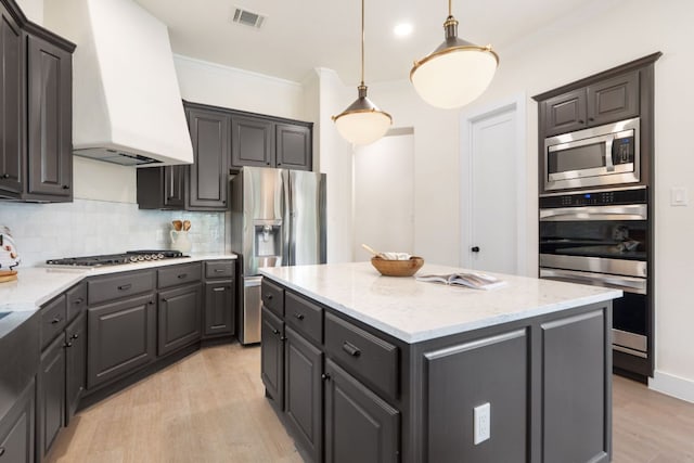 12309 Carlsbad Dr, Austin, TX 78738 - kitchen with stainless steel appliances, custom range hood, light wood-style flooring, a kitchen island, and crown molding