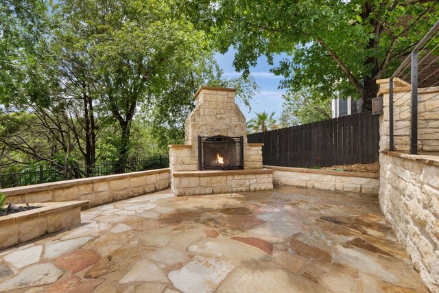 12309 Carlsbad Dr, Austin, TX 78738 - fenced backyard with an outdoor stone fireplace and a patio area