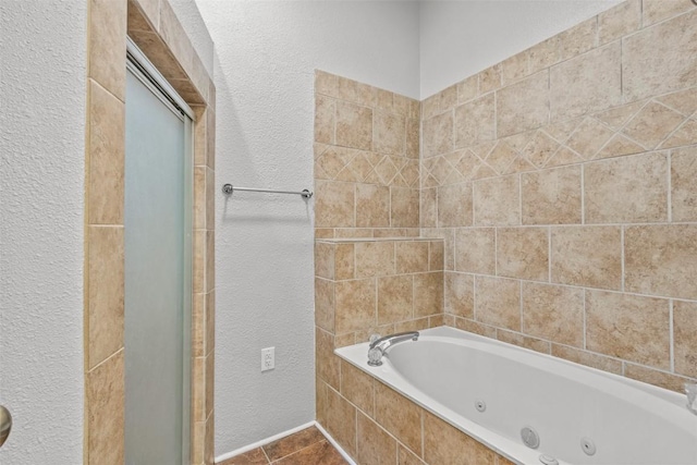 1205 Mountain View Dr, San Marcos, TX 78666 - full bathroom featuring a whirlpool tub, a textured wall, tile patterned flooring, and a stall shower