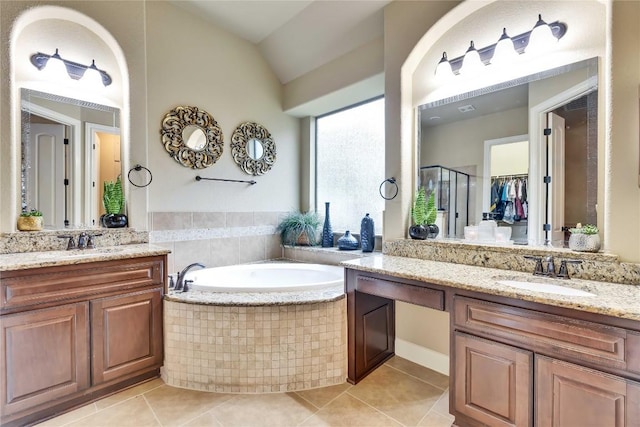 4108 Charbray Ct, Cedar Park, TX 78613 - full bathroom with tile patterned flooring, two vanities, a garden tub, a stall shower, and vaulted ceiling