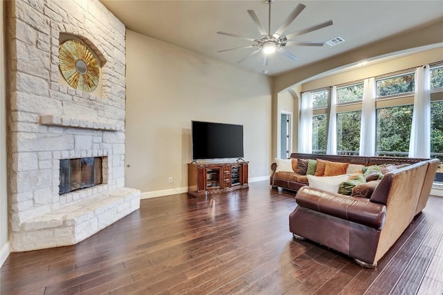 4108 Charbray Ct, Cedar Park, TX 78613 - living area featuring a stone fireplace, dark wood-style flooring, ceiling fan, and arched walkways
