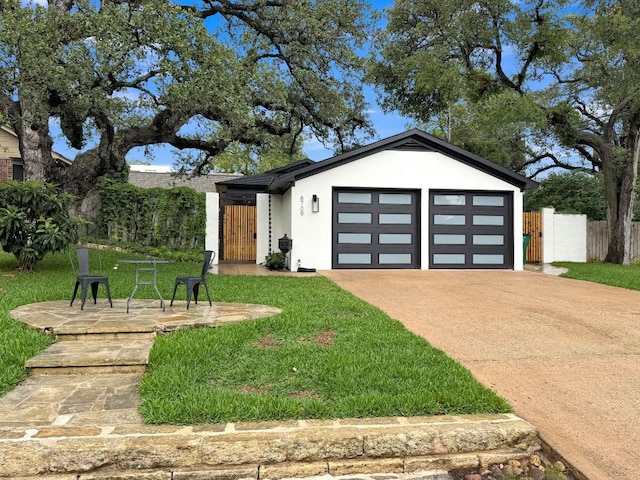 6709 Vine St, Austin, TX 78757 - view of front of property featuring stucco siding, an attached garage, concrete driveway, and a gate