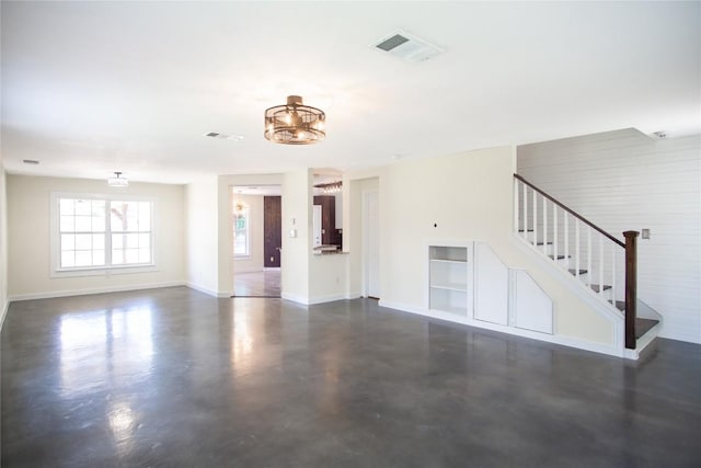 1112 Statler Bend Dr, Pflugerville, TX 78660 - unfurnished living room featuring finished concrete flooring, stairway, a chandelier, and built in shelves