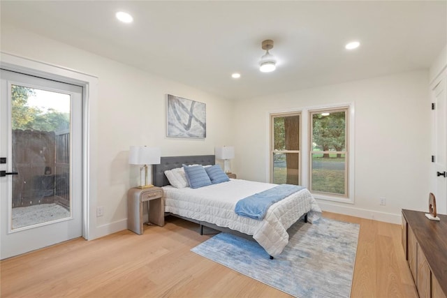 12001 Mossbrook Cv, Austin, TX 78750 - bedroom featuring multiple windows, light wood finished floors, recessed lighting, and access to exterior