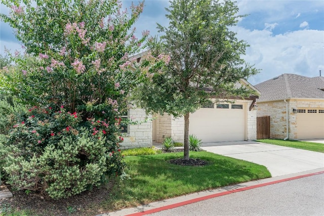 3805 Wales Ct Unit 611, Round Rock, TX 78681 - obstructed view of property featuring concrete driveway, a front yard, an attached garage, and stone siding