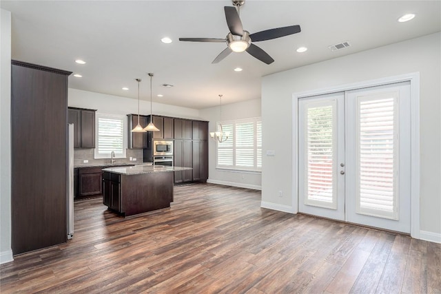 3805 Wales Ct Unit 611, Round Rock, TX 78681 - kitchen with a center island with sink, dark wood-style flooring, a ceiling fan, dark brown cabinetry, and stainless steel microwave
