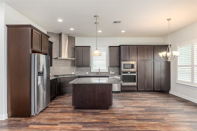 3805 Wales Ct Unit 611, Round Rock, TX 78681 - kitchen featuring stainless steel appliances, wall chimney exhaust hood, a chandelier, dark brown cabinetry, and backsplash