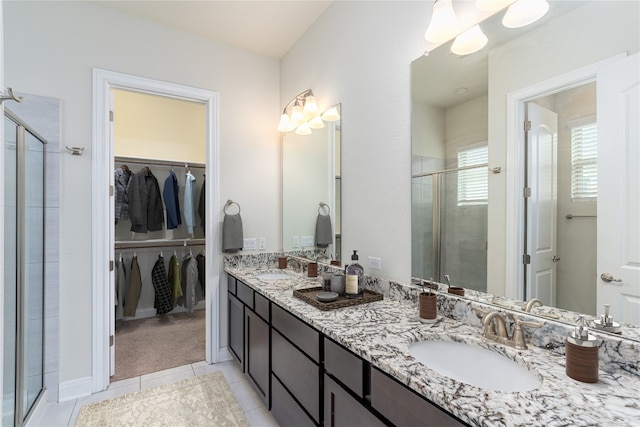 3805 Wales Ct Unit 611, Round Rock, TX 78681 - bathroom featuring a shower stall, double vanity, a walk in closet, and tile patterned floors