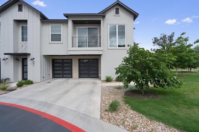 12001 Vista Parke Dr Unit 406, Austin, TX 78726 - view of front facade featuring a balcony, driveway, board and batten siding, a garage, and stucco siding