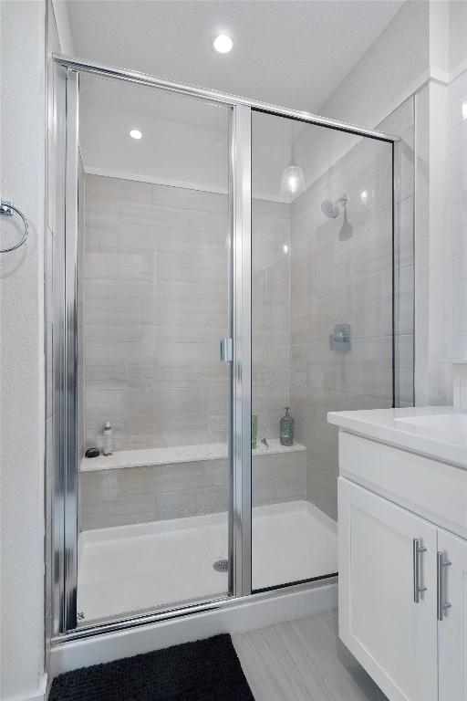 12001 Vista Parke Dr Unit 406, Austin, TX 78726 - bathroom with a shower stall, vanity, and recessed lighting