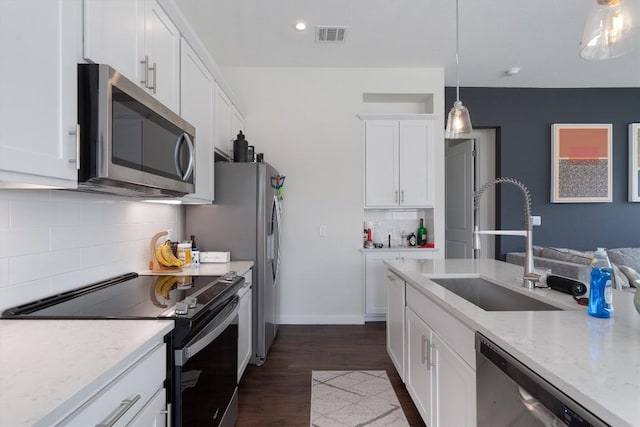 12001 Vista Parke Dr Unit 406, Austin, TX 78726 - kitchen featuring stainless steel appliances, decorative backsplash, white cabinets, pendant lighting, and dark wood-style flooring