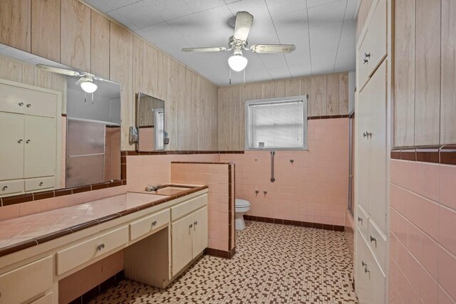 1213 Norbert St, Marlin, TX 76661 - bathroom with tile patterned floors, vanity, tile walls, ceiling fan, and a wainscoted wall