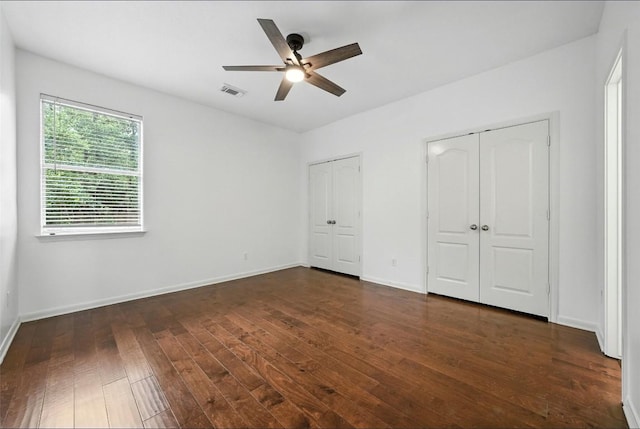 5704 Keli Ct, Austin, TX 78735 - unfurnished bedroom featuring two closets, dark wood-style floors, and ceiling fan