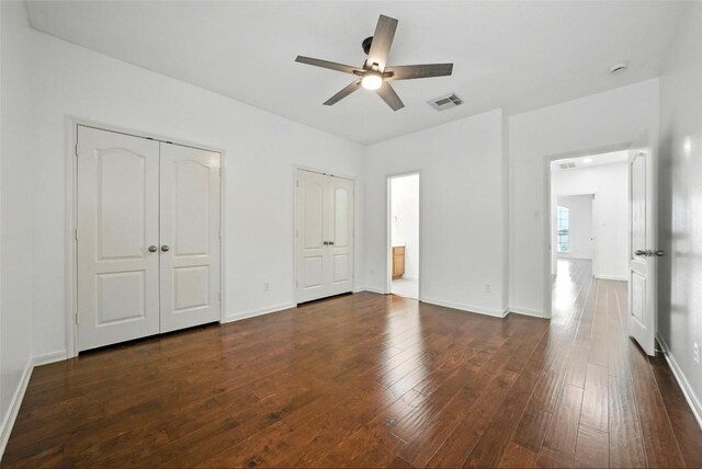 5704 Keli Ct, Austin, TX 78735 - unfurnished bedroom featuring multiple closets, dark wood finished floors, ceiling fan, and connected bathroom