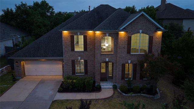 5704 Keli Ct, Austin, TX 78735 - georgian-style home with brick siding, driveway, an attached garage, and roof with shingles
