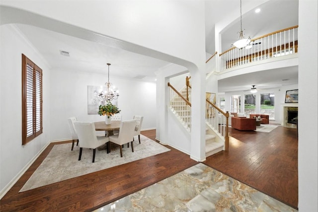5704 Keli Ct, Austin, TX 78735 - dining area with a chandelier, stairway, wood finished floors, a fireplace, and a high ceiling